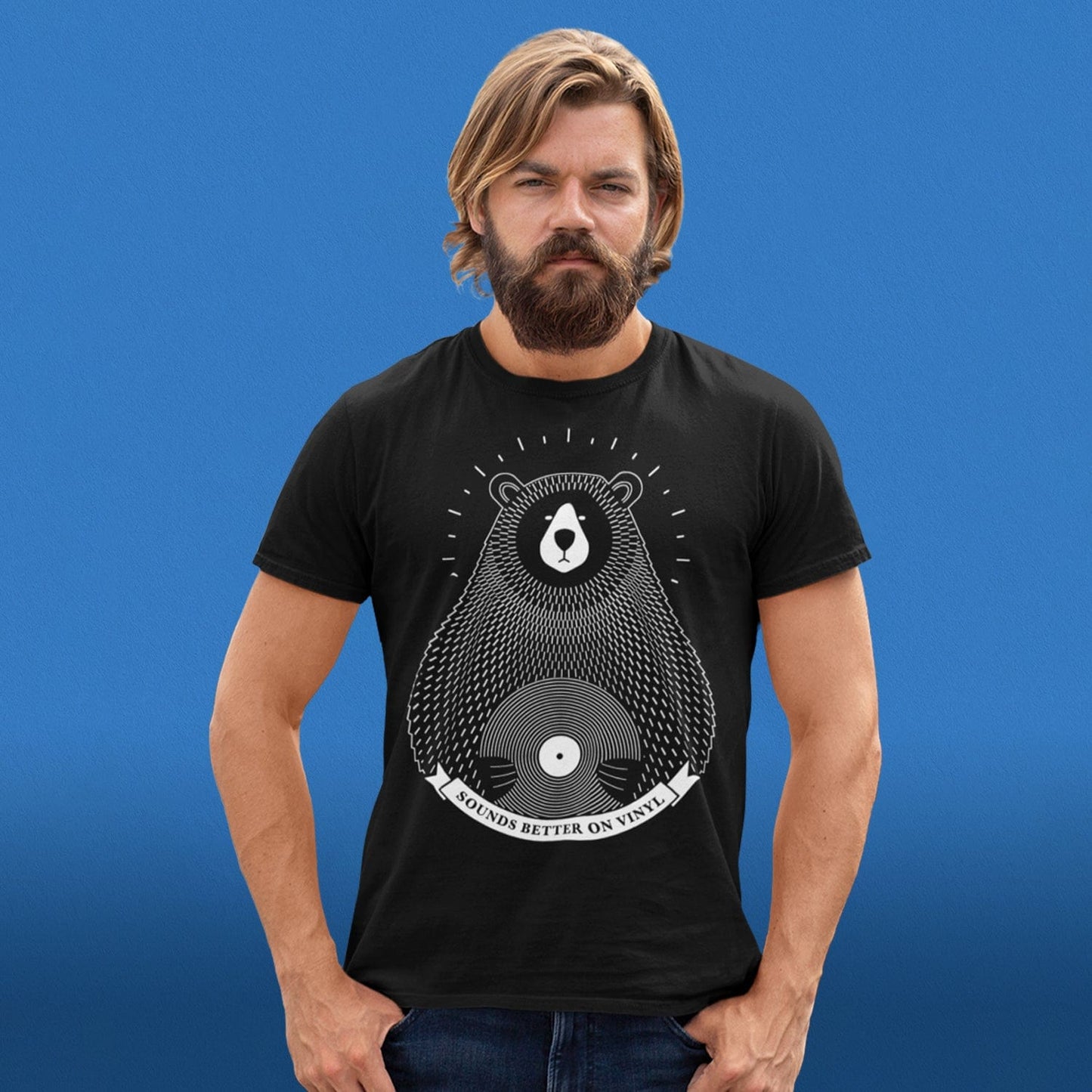 Front View of a Male Model wearing a t shirt with a vinyl record image in black organic cotton on a blue background